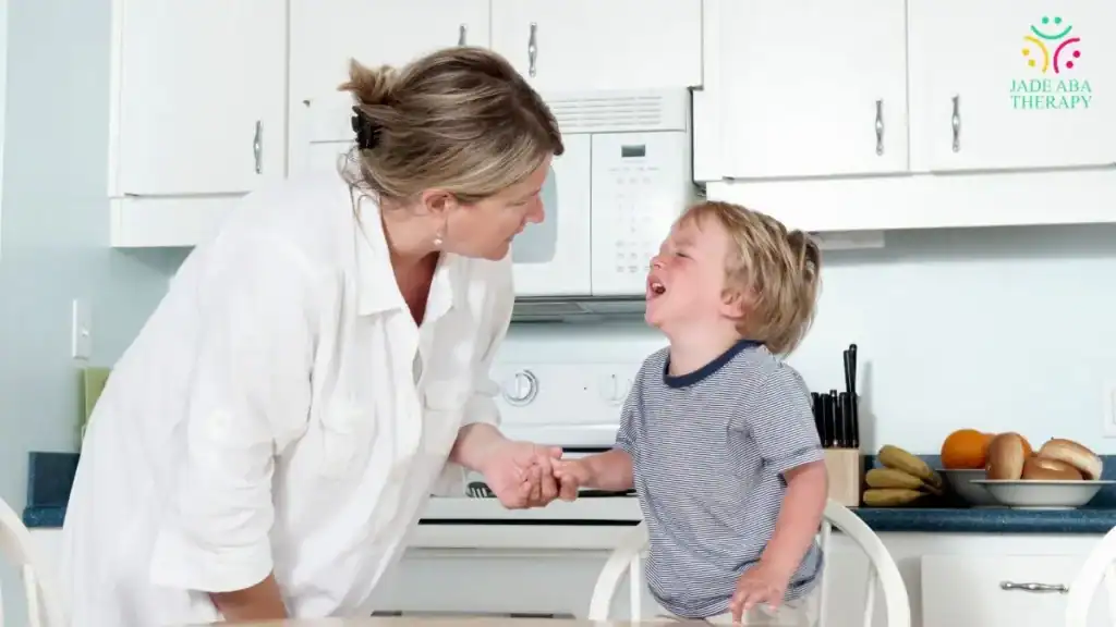 parent-comforting-crying-toddler-in-kitchen-at-home
