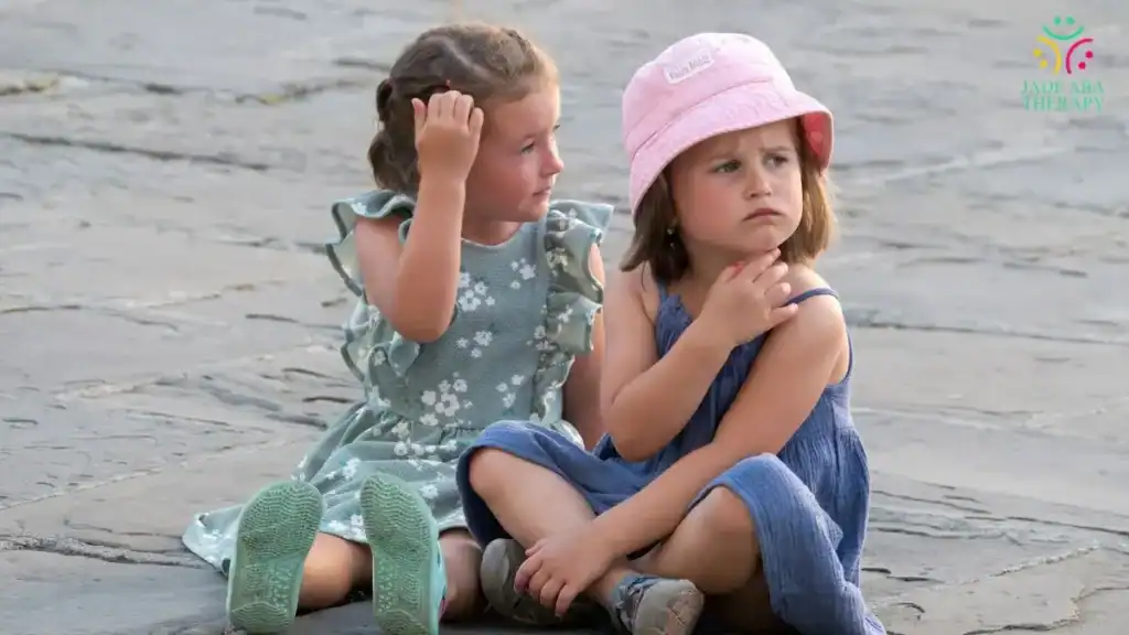 two-young-girls-sitting-outdoors-on-stone-path