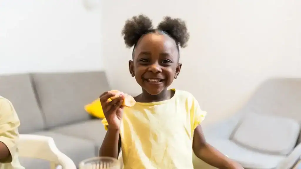 smiling-child-holding-snack-at-home